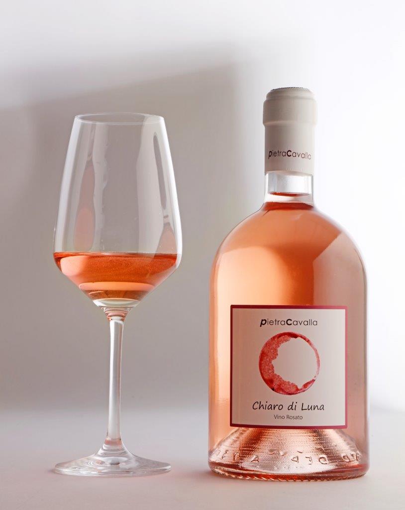Bottiglia di vino rosato "Chiaro di Luna" e calice di vino.