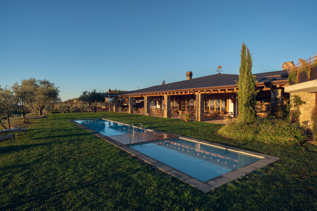 Casa rurale con piscina e ampio giardino al tramonto.