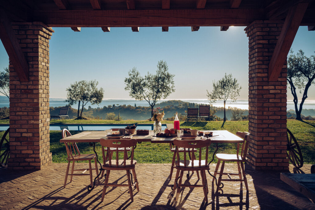 Tavolo all'esterno su una veranda con vista panoramica su un paesaggio campestre.