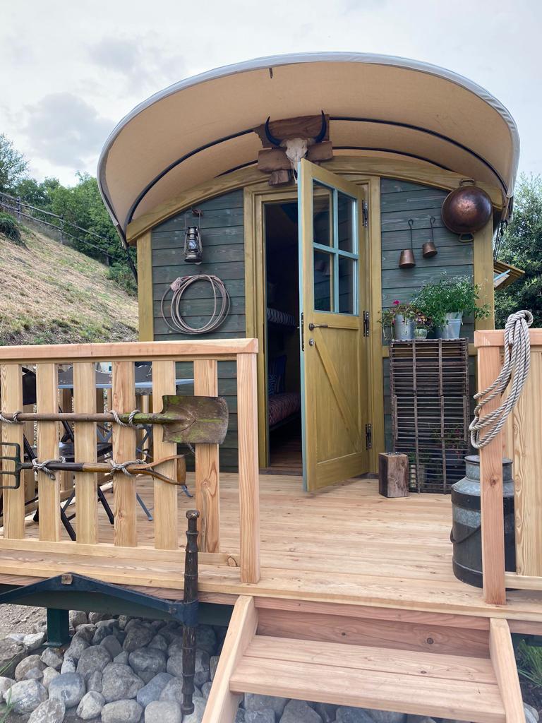 Una piccola capanna di legno con porte aperte e dettagli rustici.