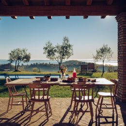 Tavolo all'esterno su una veranda con vista panoramica su un paesaggio campestre.